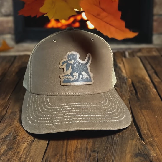 Custom leather patch trucker hat with engraved whitetail deer design – perfect for hunters, outdoorsmen, and rustic style lovers.