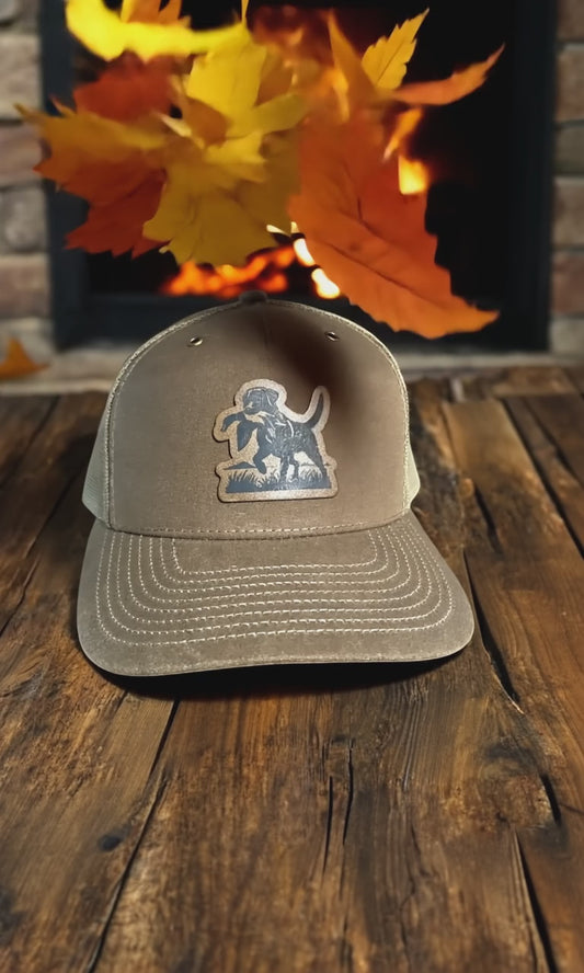 Custom leather patch trucker hat with engraved whitetail deer design – perfect for hunters, outdoorsmen, and rustic style lovers.